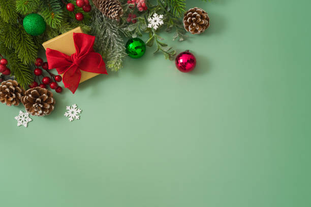 istock Christmas concept with gift box, pine tree branches and festive decorations on green background. Top view, flat lay 1709453269