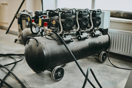 Black air compressor close up in furniture production manufactory