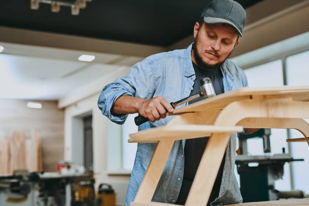 istock Carpenter works with wood in carpentry workshop. Man doing woodwork professionally 1709457695