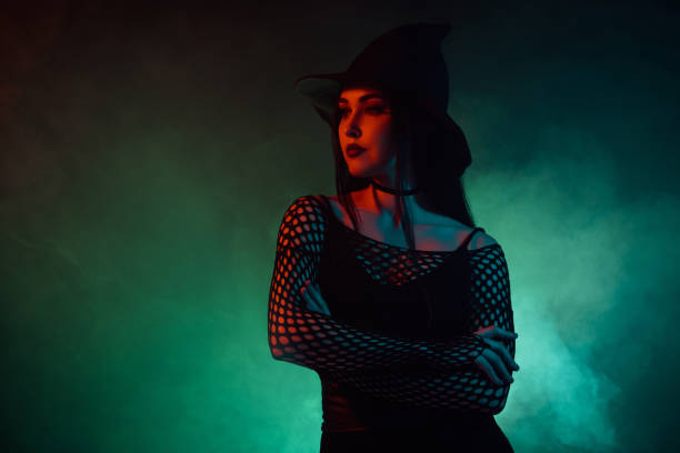 istock Photo of diabolic lady warlock doing spell ritual for summon devil from green misty hell background crossing arms 1709457699