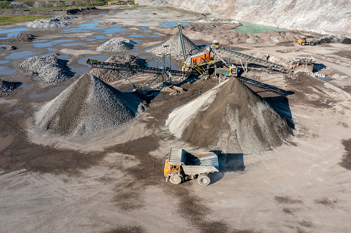 Top view shot of two industrial  workers wearing reflective jackets standing on mining worksite outdoors using digital tablet, copy space