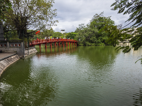 Hoan Kiem Lake in Vietnam has temples and a red bridge at night. Jade Mountain Temple and Turtle Island are points tourists visit in Hanoi, Vietnam. Hanoi, Vietnam - September 4, 2023.