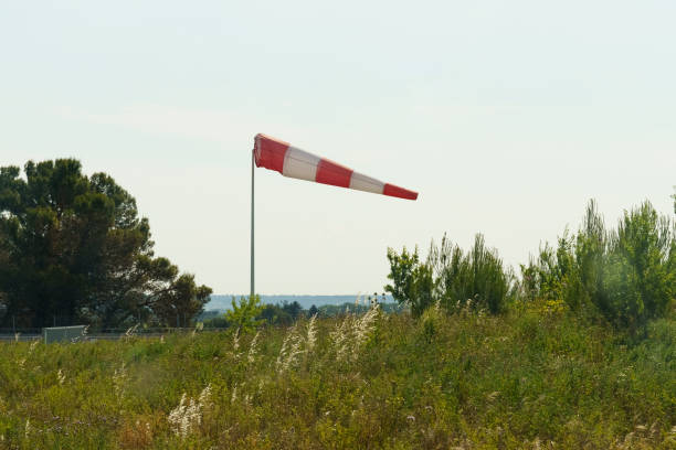 un cono de viento rojo y blanco que indica la dirección y la fuerza del viento - windsock sky natural phenomenon gale fotografías e imágenes de stock