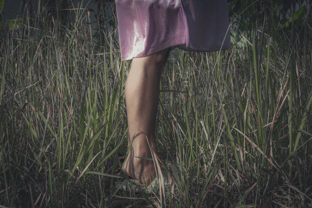 istock a woman's feet standing on a field of weeds. 1709521081