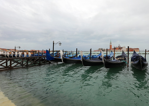 gondolas moored in the Venetian lagoon Venice during high tide without tourists