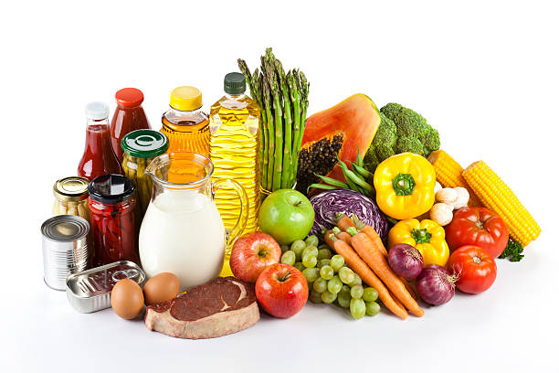 Large group of groceries arranged neatly on white table