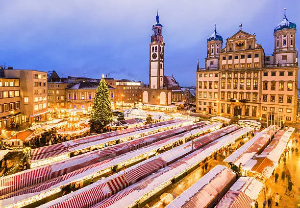 Aerial view on the Augsburger christmas market (Christkindlsmarkt) with the town hall and St. Peter am Perlach church at dusk.