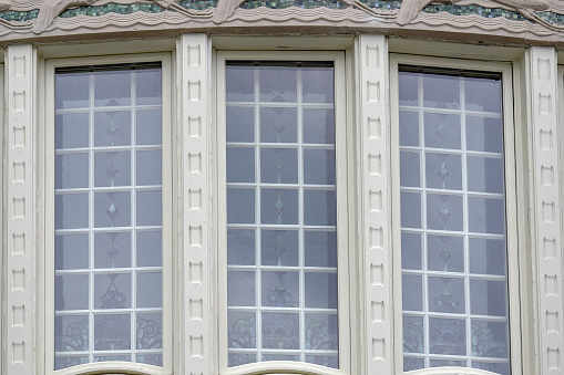 Large majestic windows with stained glass windows of the facade of the Belvedere Palace building, Vienna, Austria. The Old Town is a UNESCO World Heritage Site. Close-up. Selective focus.