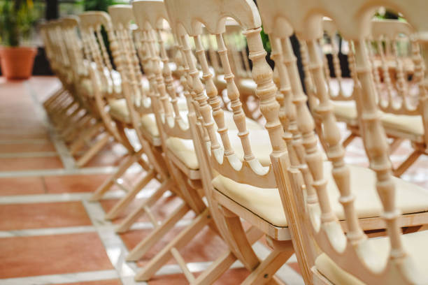 istock Many empty white wooden chairs lined up for a retro style event. 1709565206
