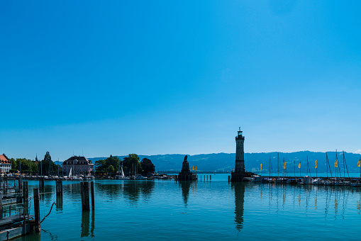 Lindau, Germany, June 14, 2023, Beautiful old harbor of the city with many ships anchoring in bodensee water with blue sky