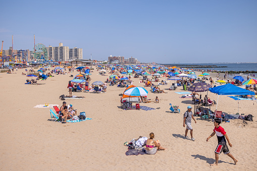 Coney Island, New York, USA - August 20th 2023:  People on the famous beach on a sunny day