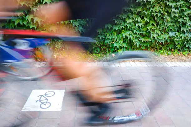 Motion blurred cyclists to show speed, driving along a bike lane, and make transport and urban displacements more sustainable.