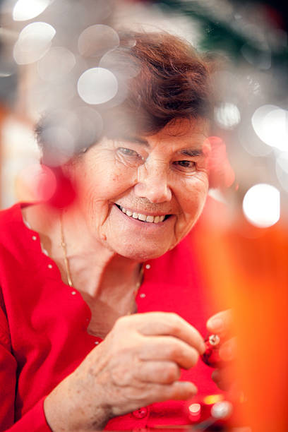 istock Senior woman decorating a christmass tree 170959230