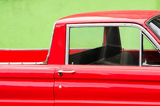 Red pickup truck parked against a green wall creates interesting contrast.  San Francisco, California, 2008.