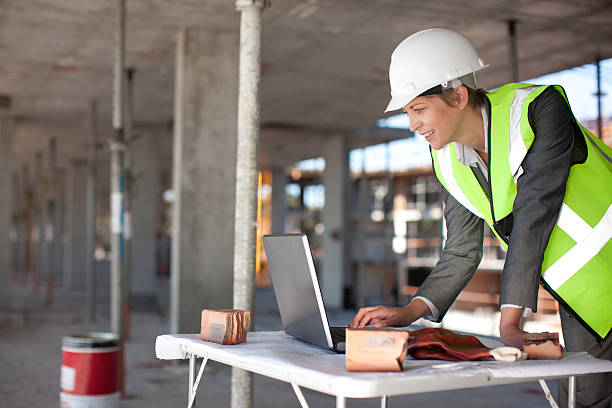 Construction worker using laptop on construction site  convenience photos stock pictures, royalty-free photos & images