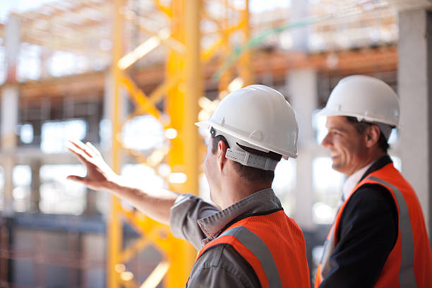 pracowników budowlanych w pracy na plac budowy - foreman building contractor hardhat men zdjęcia i obrazy z banku zdjęć