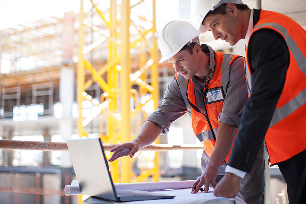 bau arbeiter mit laptop auf baustelle - building contractor computer internet construction worker stock-fotos und bilder