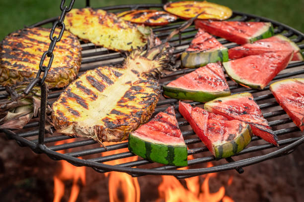 istock Roasted watermelon and pineapple with flames on bonfire. 1709622436