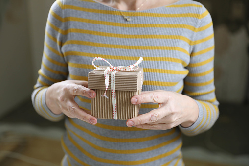 Female hands holding gift box. Christmas present.