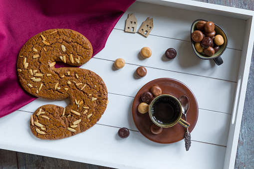 A cup of coffee and spiced bisquit called speculaas on a tray to celebrate 'het heerlijk avondje van Sinterklaas', the traditional Saint Nicolas evening