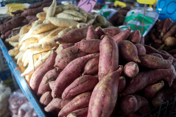 mucchio di patate dolci fresche alla bancarella del mercato - raw potato farmers market market stall vegetable foto e immagini stock