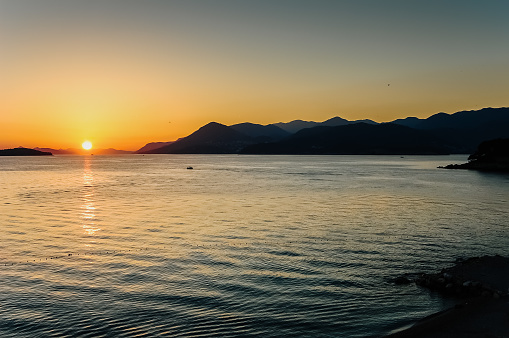 Sun was about to hide behind the horizon of the sea and the mountains at nightfall.