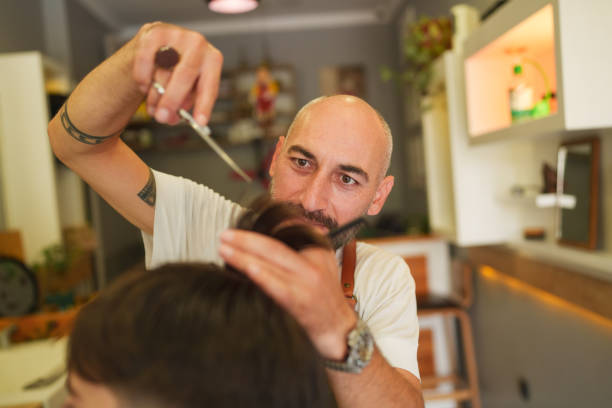 istock The barber is cutting hair with scissors. 1709762865