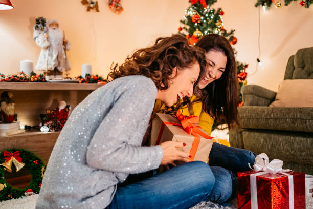 Two Friends Exchanging Gifts For Christmas