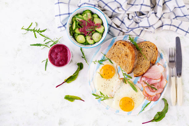 istock Breakfast. Fried egg, slices of ham, toasted bread and beetroot smoothie. Top view 1709812683