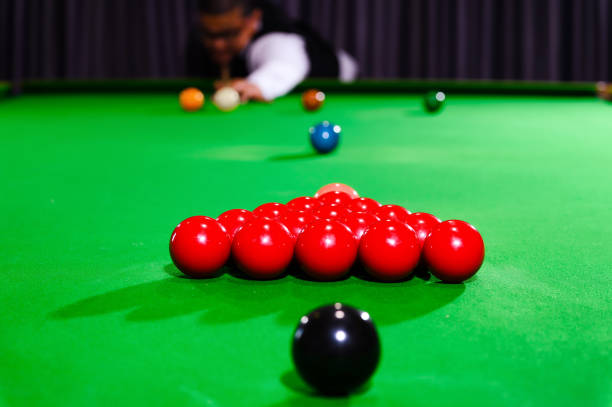 istock Snooker red ball group set with snooker player blur in background while aiming red ball on snooker table. Selective focus on red ball group set foreground. 1709813332