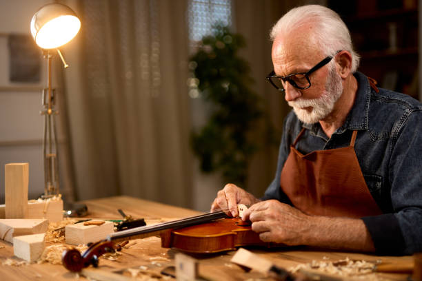 istock Senior carpenter craftsman making violin instrument 1709834871
