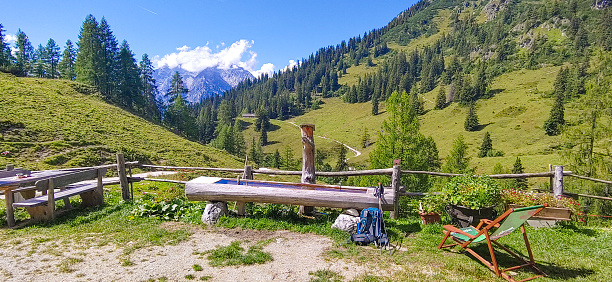 Wanderpause auf einer Almhütte mit dem Watzmann im Hintergrund im Nationalpark Berchtesgaden in den Alpen