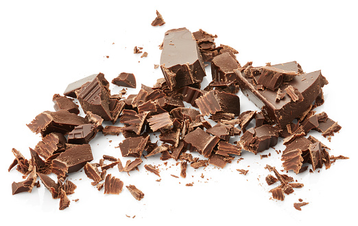 Chocolate pieces and chocolate shavings isolated on white background