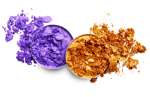 Crushed purple and gold eye shadow isolated on white background