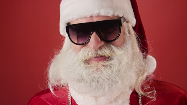 Portrait of Hipster Santa Claus Putting on Sunglasses