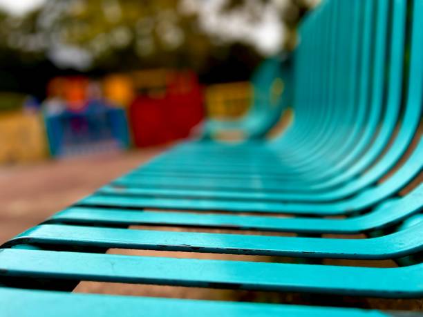 A turquoise metal park bench