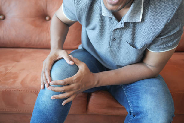 istock n man suffering knee joint pain sitting on sofa at home 1709870462