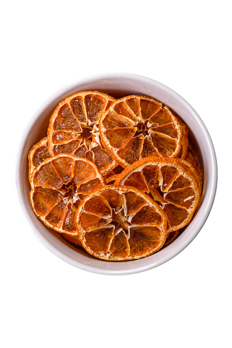 Dried round slices of tangerine, orange or lemon on a dark concrete background. Ingredient for making sweets