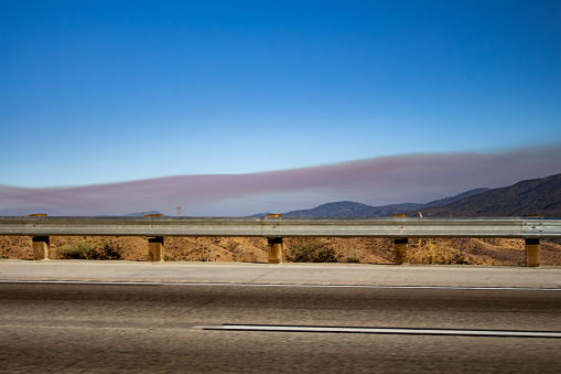 Thick layer of grey brown smog over the hills near the highway