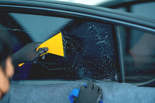 istock Technician uses equipment to install car window film. 1709933399