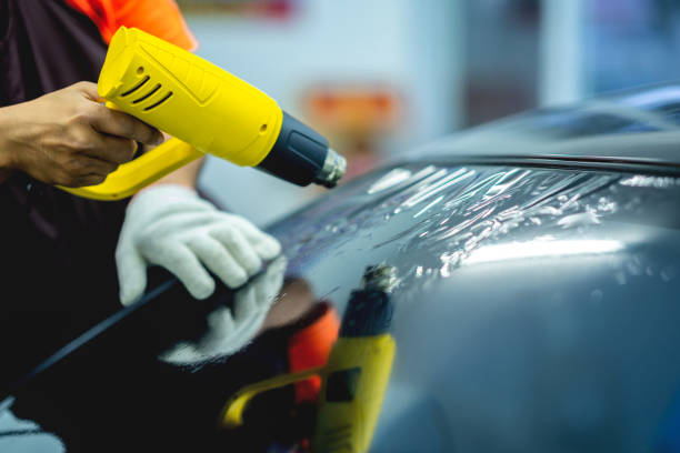 istock Technician uses equipment to install car window film. 1709933956