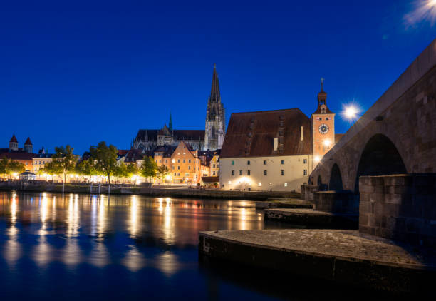 Regensburg cityscape during blue hour with light reflections in the river Danube