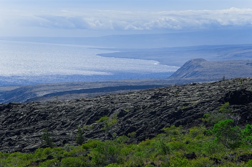 Views across the lava field from Volcano national park Hawaii into the Pacific ocean. The stark landscape across lava and the southeast coastline of the Big Island of Hawaii.