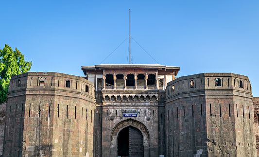 Historical , ancient, stone made monument named Shaniwar Wada in Pune. Text in local language is name Shaniwar Wada.