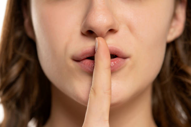 istock woman lips with finger asking for silence 1709982135