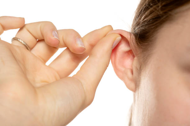 closeup of woman pull her ear on a white background stock photo