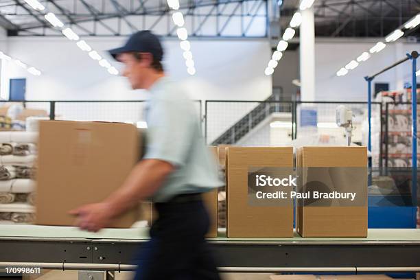 Worker Carrying Box In Shipping Area Stock Photo - Download Image Now - Urgency, Warehouse, Freight Transportation