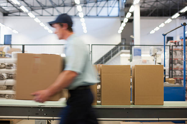 trabalhador transportar caixas na área de envio - cardboard box package box label imagens e fotografias de stock
