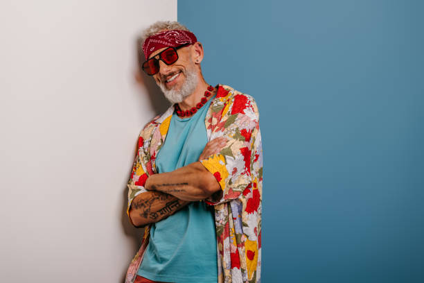 istock Happy senior man in stylish funky shirt leaning at copy space while standing against blue background 1710029161