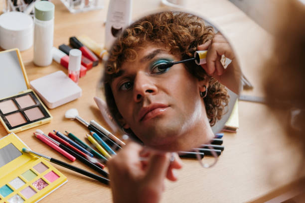 istock Top view of confident young gay man looking at his reflection in the mirror while applying make-up 1710081193